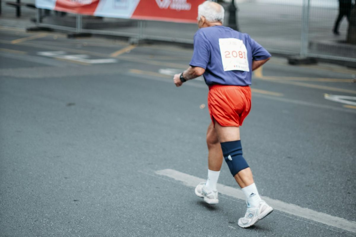 Homme âgé qui fait un footing sur une route