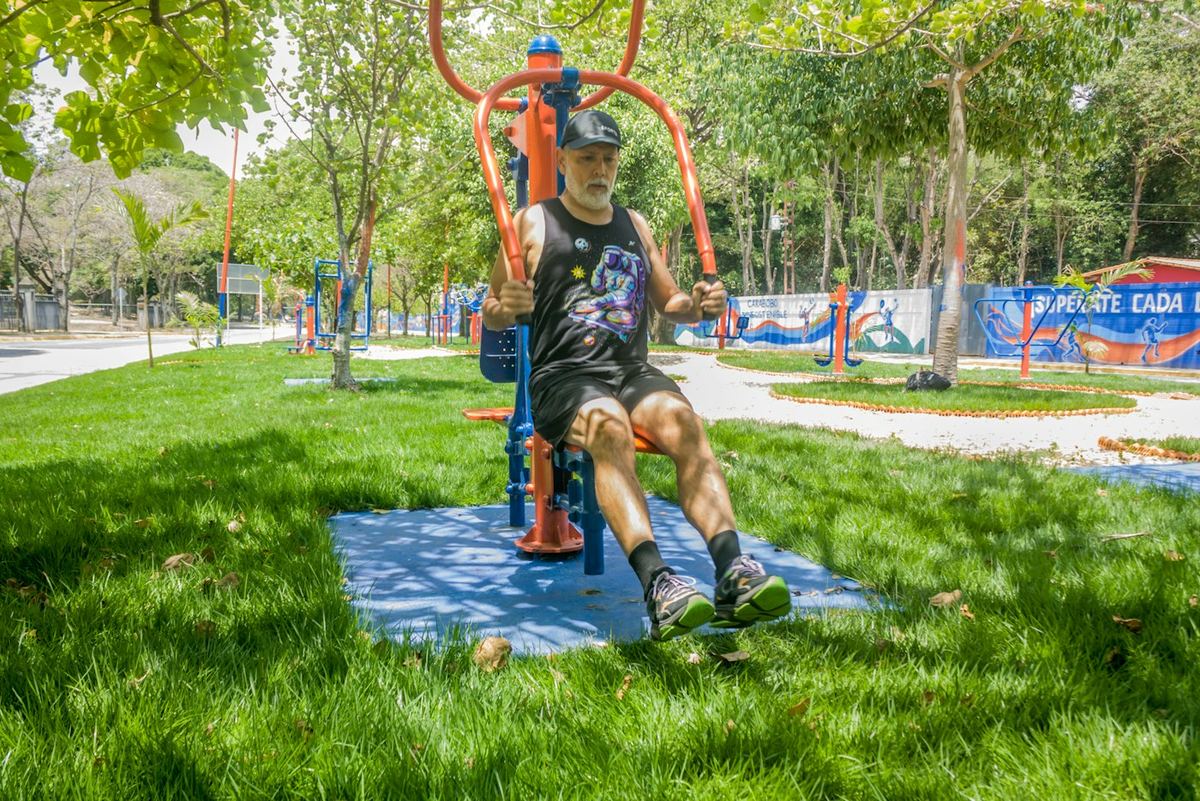Homme qui s'entraîne sur un appareil de fitness en plein air dans un parc